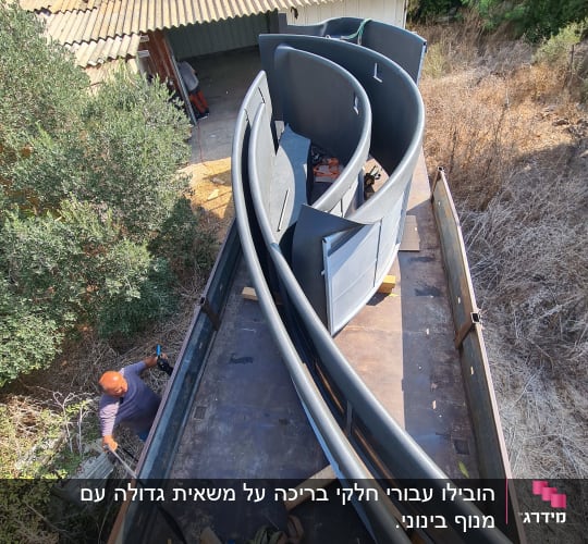 חלקי מנוף מונחים על משאית עם רצועות קשירה